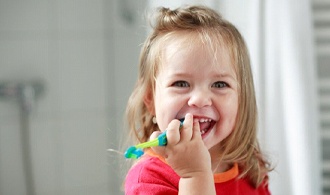 toddler girl holding a toothbrush 