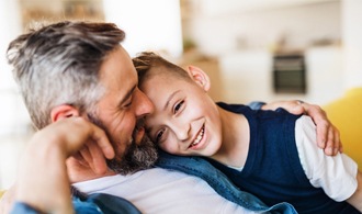 Father and son hugging on a couch