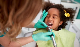 little girl receiving treatment from dentist