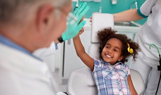 little girl giving dentist high-five 
