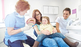 dentist examining little boy’s mouth 