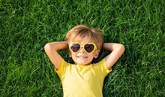 Smiling child reclining on grass