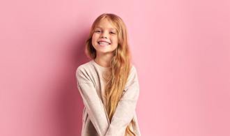 Happy girl pictured against pink background