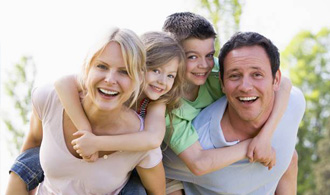 Smiling mother father and two kids outdoors