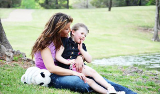 Smiling mother and daughter outdoors