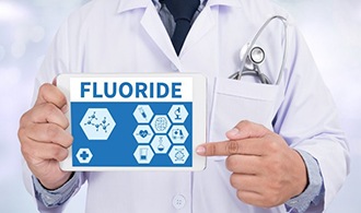 dentist pointing to fluoride on tablet 