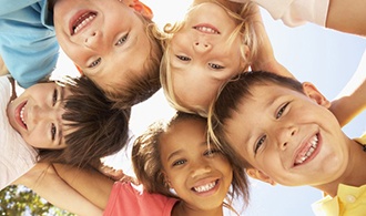 A group of children smiling in a circle.