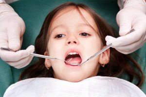 little girl mouth open dental exam