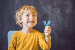 Little boy holding custom mouthguard from Hillsboro pediatric dentist