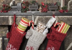 Three stockings full of gifts hung on a mantle