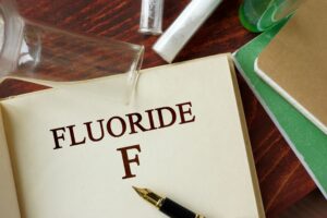 Notebook with "Fluoride F" on a table with chemistry vials