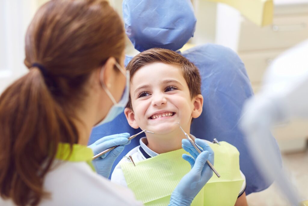 Boy in dental chair smiling before dental exam